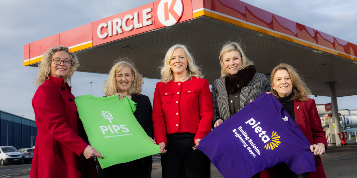 Representatives of Circle K and Pieta holding t-shirts of Pieta and PIPS, posing in front of a CK station