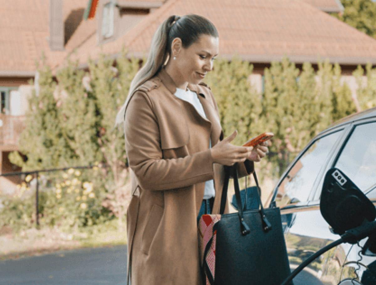 A woman checking her mobile phone at the forecourt